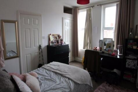 A cozy bedroom featuring a comfortable bed, a d...