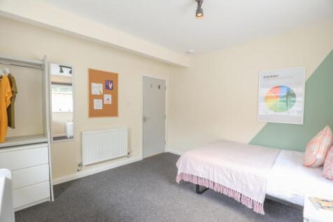 A clean and inviting single bedroom with a comf...