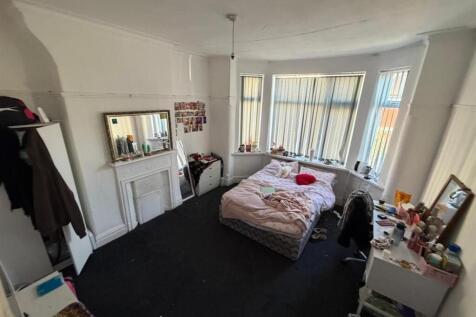 Spacious bedroom with a bright bay window...