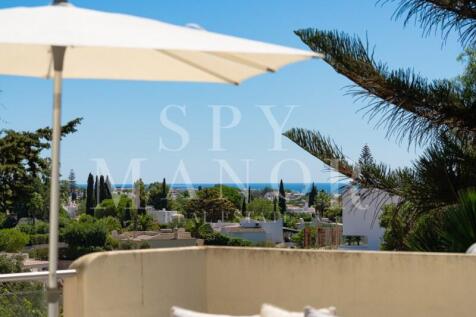 First-floor terrace with parasol offering distant sea views over Carvoeiro Clube, Algarve, from a luxury Moorish villa for sale.