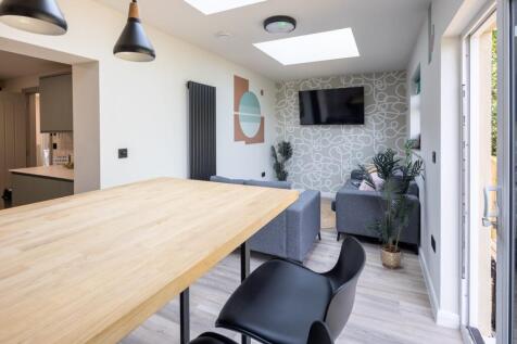 Bright modern living area with skylights and TV...