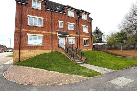 Modern red brick building with manicured lawn...