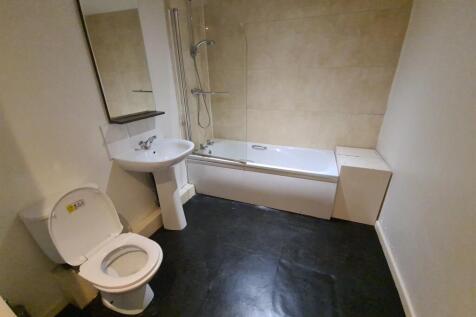 A spacious bathroom featuring a large bathtub, ...