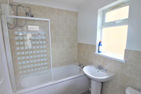 Bright bathroom featuring a full tub and shower...