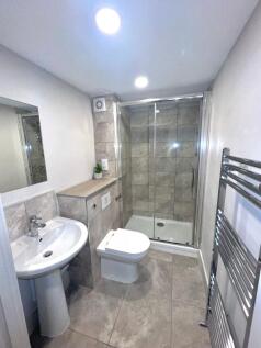 Modern tiled bathroom with a walk-in glass show...
