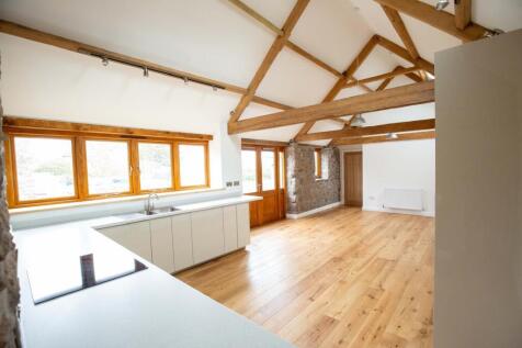 Bright open-plan living space with exposed timb...