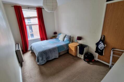 Cozy single bedroom featuring a comfortable bed...