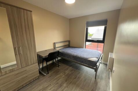 A well-lit, clean single bedroom featuring a be...