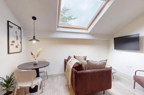 Bright lounge with skylight and chic dining are...