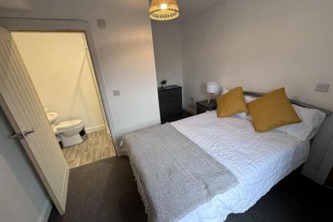 Bright and cozy master bedroom featuring a comf...