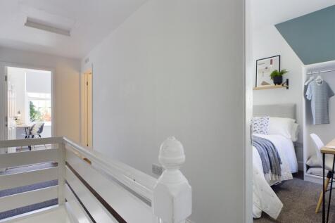 A bright and tidy hallway leading to well-maint...