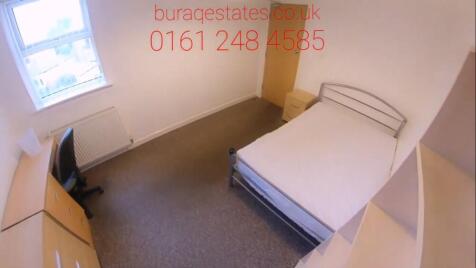 Bright, simply furnished bedroom with a double ...