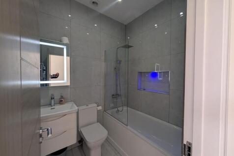 Modern bathroom with sleek tiles and LED mirror...