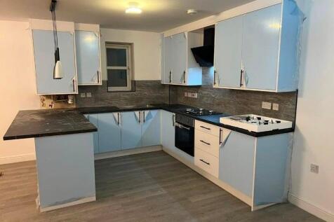 Modern fitted kitchen with L-shaped worktops, i...