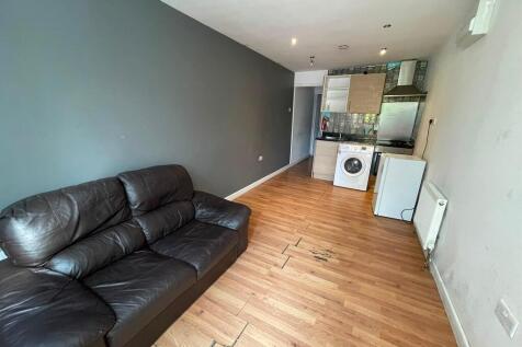 Open-plan living space with a sofa and kitchen...
