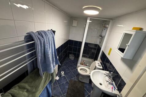 Tiled bathroom with a corner shower cubicle, pe...