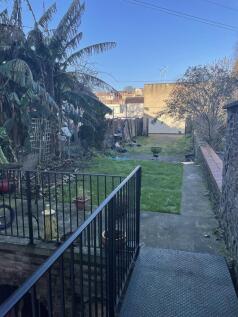 Long rear garden with a paved terrace, central ...