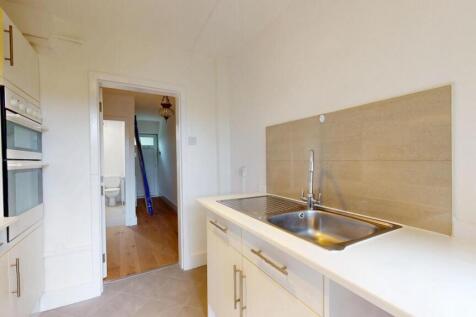 Bright and clean kitchen area with modern fixtu...
