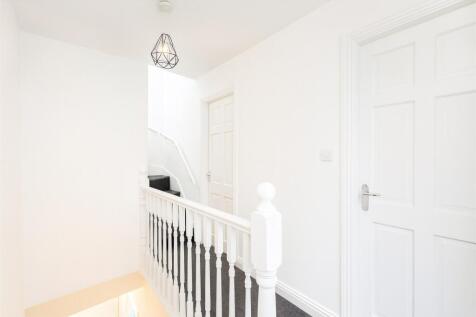 Bright, freshly painted upstairs hallway with w...