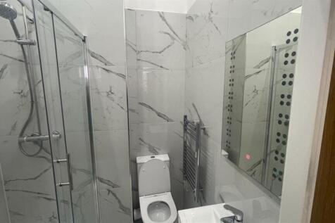 Modern bathroom with marble-effect wall tiles, ...