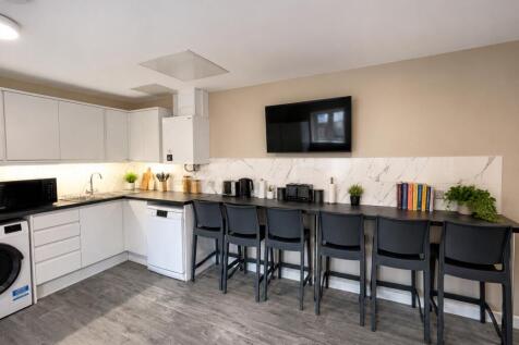Modern kitchen with a sleek breakfast bar and T...