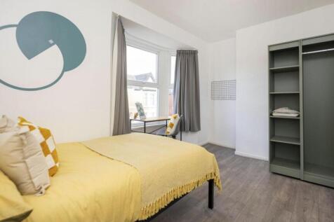 A bright and inviting double bedroom with styli...