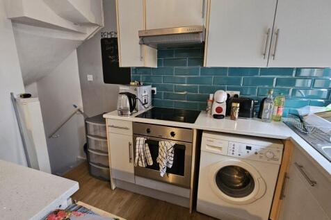 Compact and modern kitchen space featuring whit...