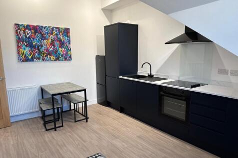 Modern open-plan kitchen with sleek black cabin...