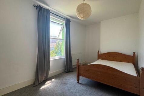 Bright and airy bedroom with classic wood bed...