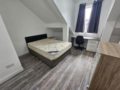A bright double bedroom featuring a comfortable...