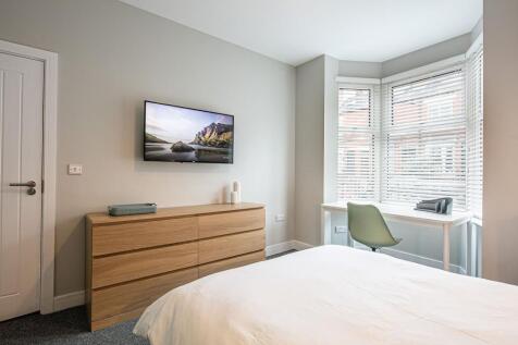 Bright and modern bedroom featuring a large win...