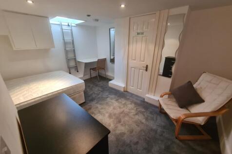 Cozy single bedroom featuring a bright skylight...