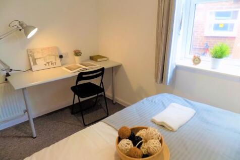 A cozy and tidy single bedroom featuring a neat...