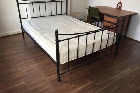 Bright bedroom with a metal-framed double bed, ...