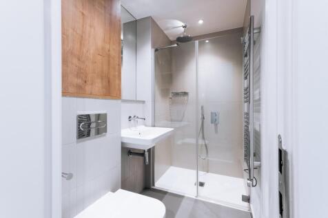 Embrace modern living with this elegantly designed bathroom, featuring a chic shower and minimalist aesthetic.