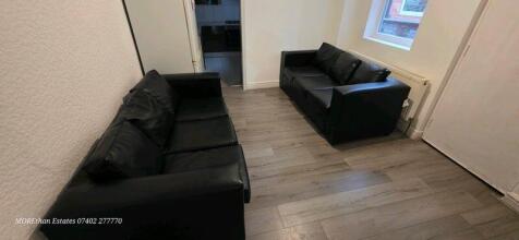 Bright, modern communal lounge with two black l...