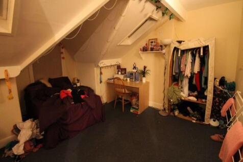 A cozy attic room with slanted ceilings featuri...