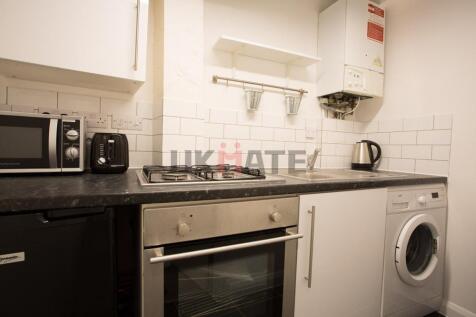 A modern kitchen featuring a black countertop, ...