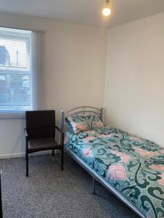 Bright bedroom with large window and comfy chai...