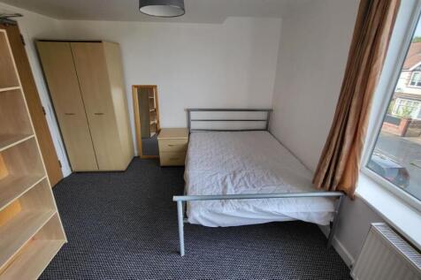 Bright, simply furnished bedroom with a window ...