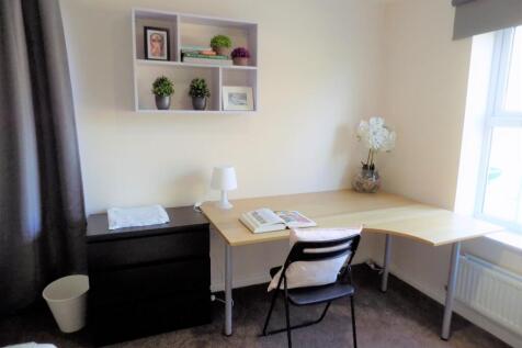 Bright, neatly furnished bedroom corner with a ...