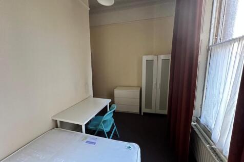 Bright single bedroom with a large sash window,...