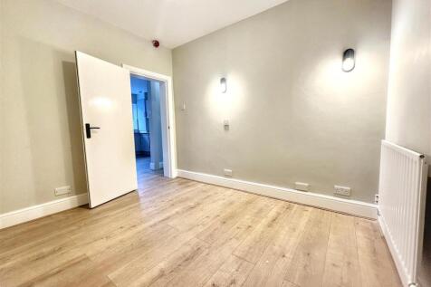 Bright room with neutral decor and wood floorin...