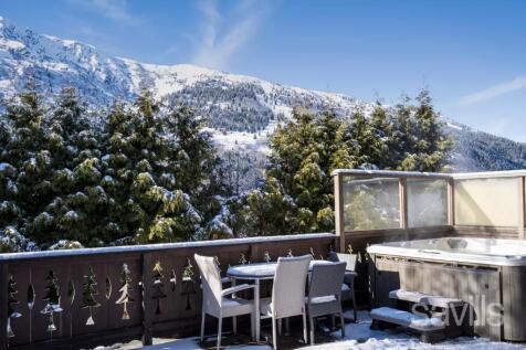 A snowy mountain view from a cozy patio with a hot
