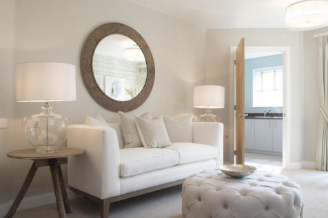 a living room with a white couch and a round mirror