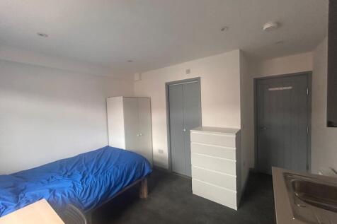 Compact room with bed, storage and kitchenette...