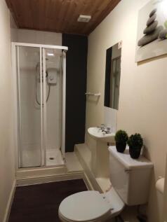 Neat, modern bathroom featuring a glass-enclose...