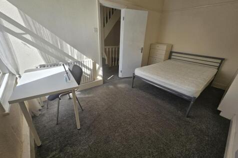 A modest, well-kept single bedroom with natural...