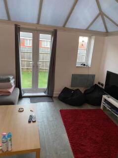 Bright living room with French doors opening to...
