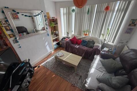 Bright living room with large bay window and so...